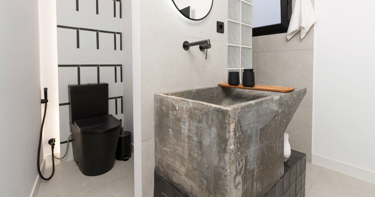 Baño reformado con lavabo de obra, sanitarios modernos y acabados en tonos neutros.
