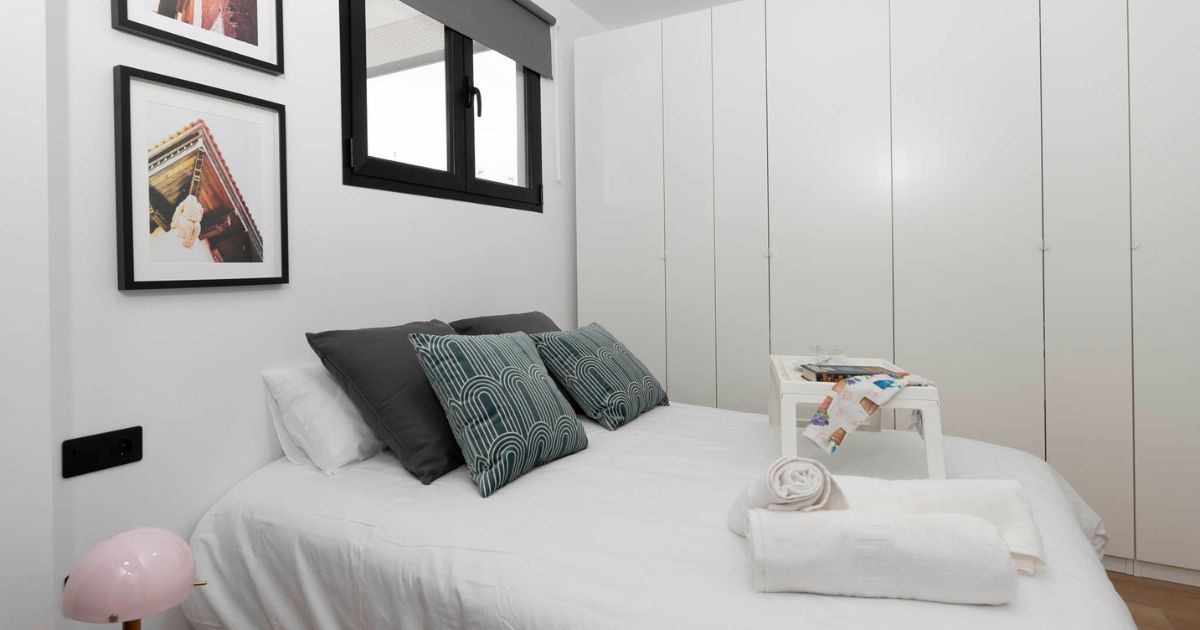 Dormitorio reformado con armarios empotrados y decoración minimalista tras reforma integral.