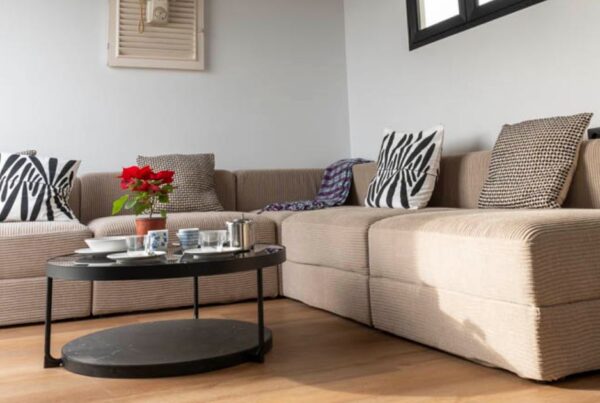 Zona de estar reformada por Mondalón Reformas con sofá y, mesa de centro