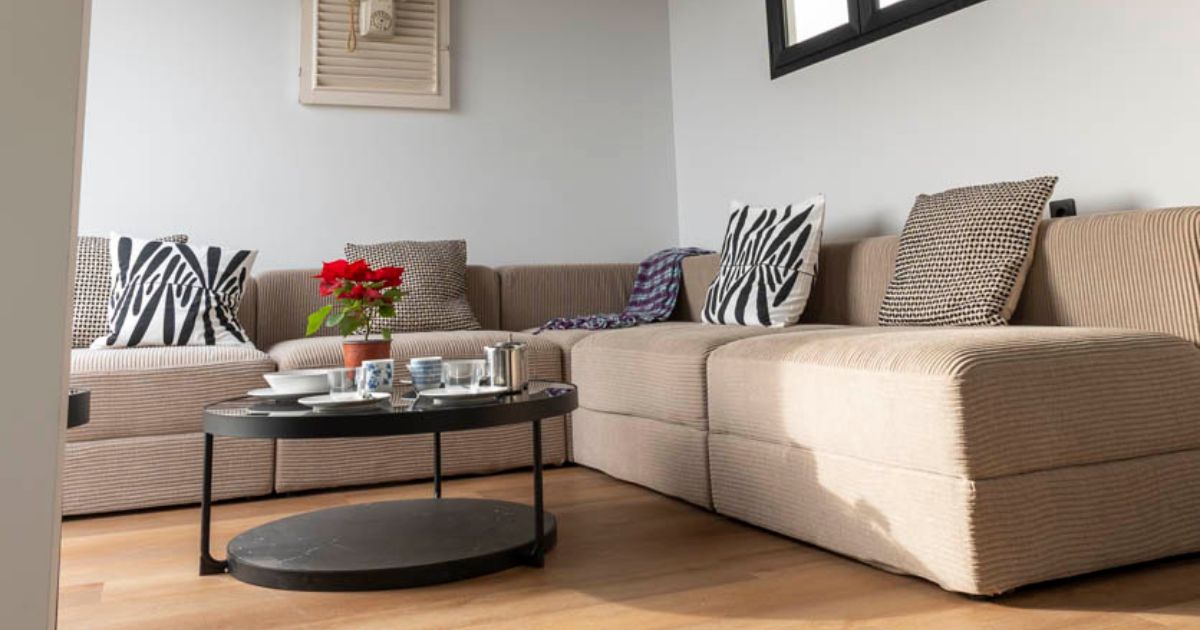 Zona de estar reformada por Mondalón Reformas con sofá y, mesa de centro